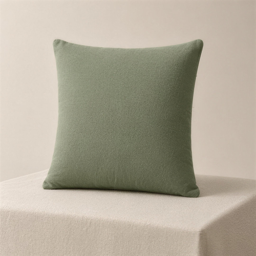The Case in sage, a square cushion cover in one flat muted green, standing upright on a plinth.